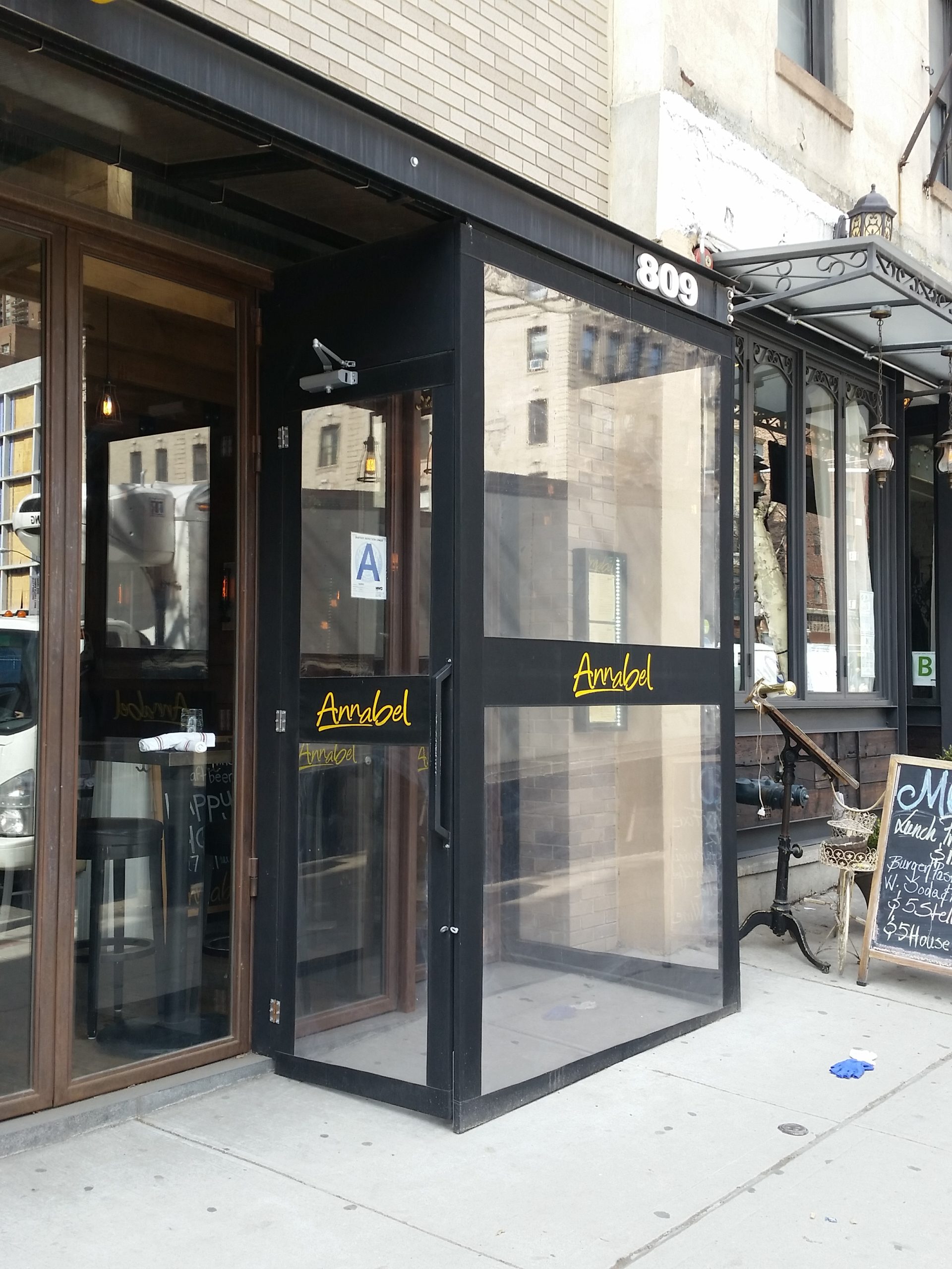 Black-framed glass storefront entrance enclosure — Glass entrance vestibule