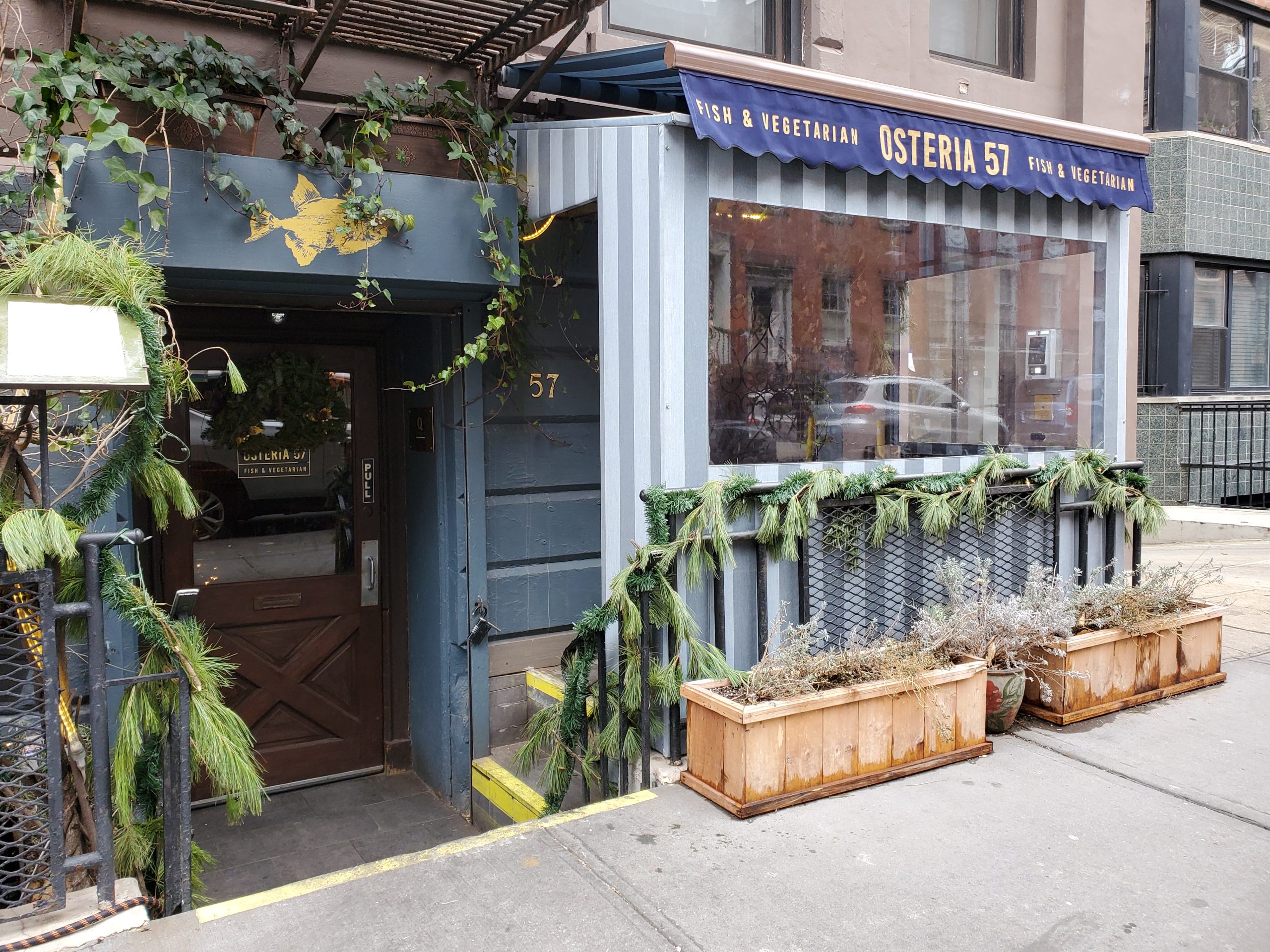 Restaurant storefront with custom awning and planted street frontage